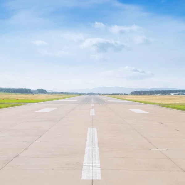 Start-en landingsbaan op de luchthaven in zonnige zomer middag met wolken — Stockfoto