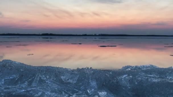 Videó a jég sodródás a széles és nyugodt Amur folyó alatt a rózsaszín naplemente — Stock videók