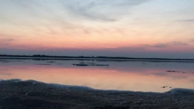 Pembe günbatımında geniş ve sakin Amur nehrinde buz akıntısı videosu