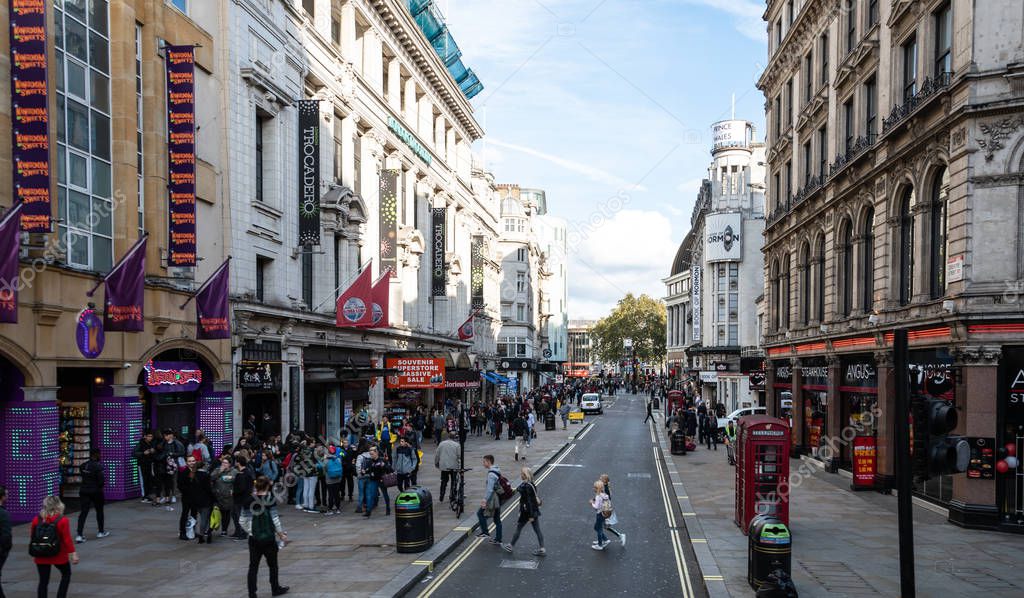 London, United Kingdom - October 18 2018:   A view of shops, shoppers and tourists along Coventry Street towards Leicester Square