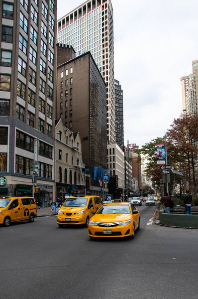 New York City, United States - November 17 2018: Three New York Yellow Taxis pulling away from Traffic lights on Central Park West