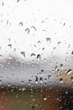 Yağmurlu bir günde pencere camındaki yağmur damlalarının soyut bir görüntüsü
