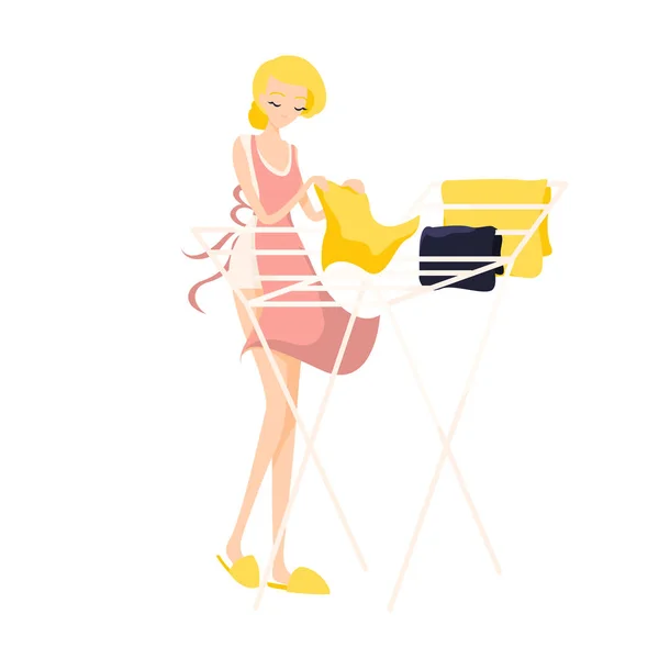 Menina loira bonito pendura roupa limpa lavada em um avental rosa —  Vetores de Stock