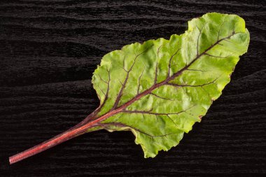 Pancar yeşillik flatlay siyah ahşap arka plan üstten görünüm üzerinde bir yeşil lea izole.