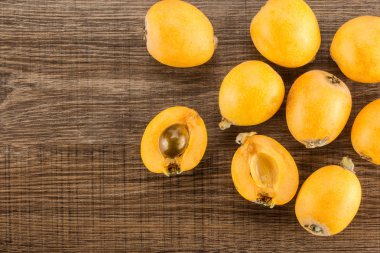 Bir iki yarım flatlay izole kahverengi ahşap adam kesilmiş taze turuncu Japon yenidünya