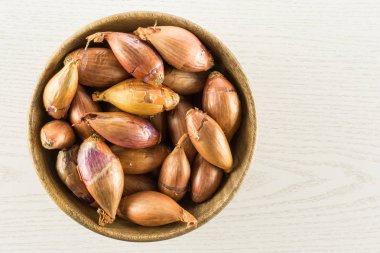 Üzerinde gri odun adam izole bir ahşap kase üst görünümünde uzun soğancık
