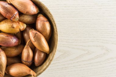 Üzerinde gri odun adam izole bir ahşap kase flatlay uzun soğancık