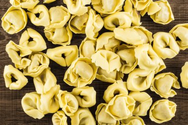 Ham tortellini makarna flatlay kahverengi ahşap zemin İtalyan geleneksel dumplin üzerinde