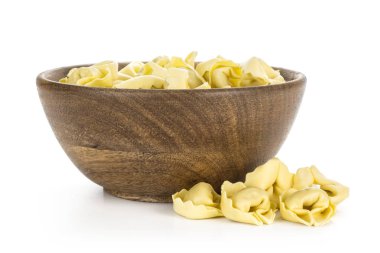 Beyaz arka plan üzerinde geleneksel hamur tatlısı izole bir ahşap kase çiğ İtalyan tortellini makarna
