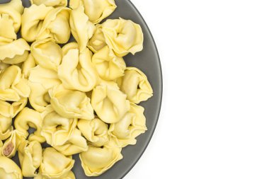 Beyaz arka plan üzerinde İtalyan geleneksel dumplin izole bir gri seramik tabak flatlay ham tortellini makarna