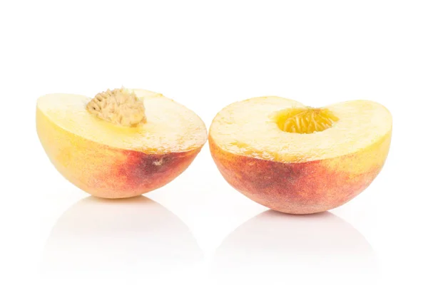 Two halves of yellow peach isolated on white background cross section with a drupe insid
