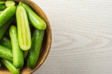 Gri odun adam ahşap bir kase taze mini salatalık