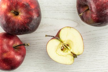 Kırmızı lezzetli üç elma ve yarım flatlay gri odun adam üzerinde