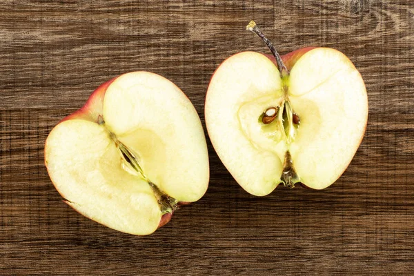 Kırmızı lezzetli elma iki bölüm yarım flatlay kahverengi ahşap adam üzerinde