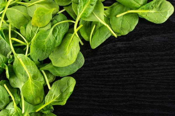 Siyah ahşap arka plan sol üst corne en iyi görünümü taze bebek ıspanak yaprakları