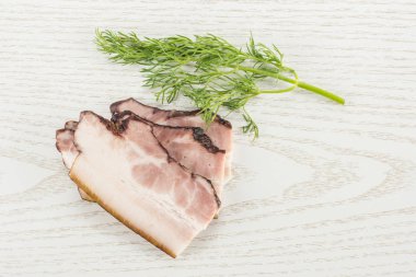 Üç dilim İngilizce pastırma gri ahşap üzerine dereotu flatlay sapı ile Grup