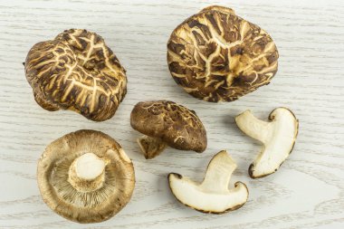 Grup dört tüm iki dilim taze çiğ kahverengi shiitake mantar flatlay gri izole woo