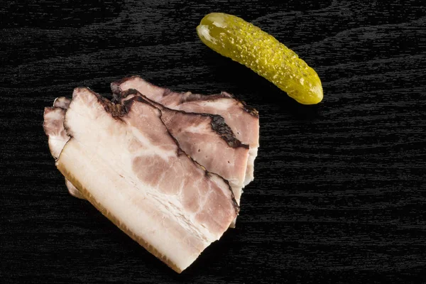 Üç dilim İngilizce pastırma ile tuzlu salatalık flatlay siyah ahşap üzerine Grup