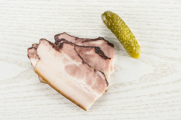 Üç dilim İngilizce pastırma bir tuzlu salatalık flatlay gri Wood ile Grup