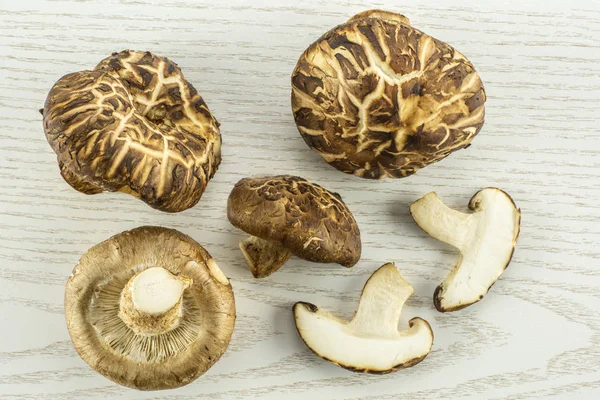 Grup dört tüm iki dilim taze çiğ kahverengi shiitake mantar flatlay gri izole woo