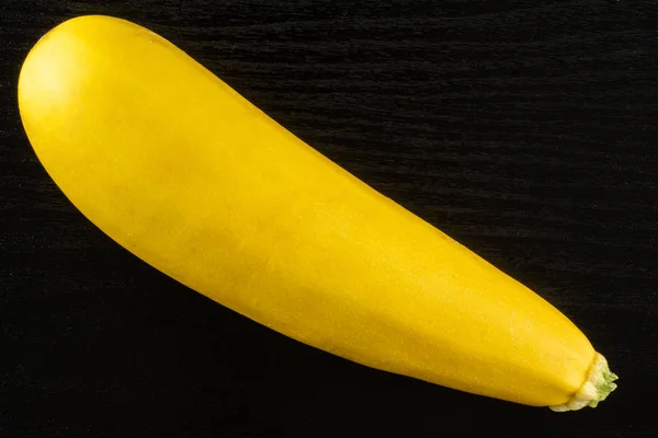 Fresh Raw yellow zucchini on black wood — Stock Photo, Image