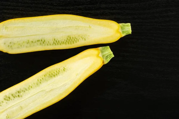 Färsk rå gul zucchini på svart trä — Stockfoto