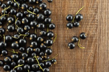 Lot of whole fresh black currant berry ben gairn variety several berries are separated flatlay on brown wood clipart