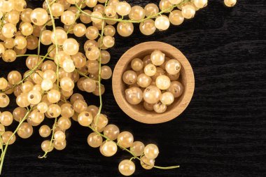 Bütün taze beyaz üzümü berry blanka çeşitli ve ahşap kase çilek flatlay siyah ahşap üzerine dolu çok