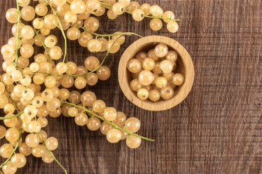 Bütün taze beyaz üzümü berry blanka çeşitli ve ahşap kase çilek flatlay kahverengi ahşap üzerine dolu çok