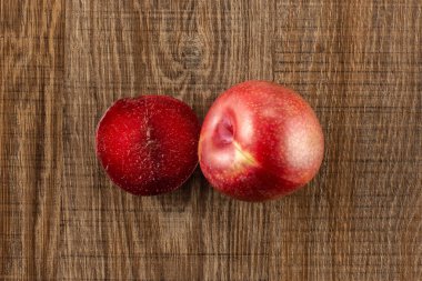 Grup bir bütün yarım taze pluot interspecific Erik çeşitli flatlay kahverengi ahşap üzerine