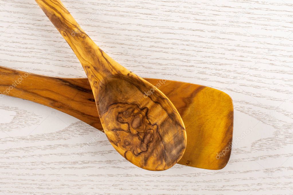 Group of two whole kitchen tool olivewood spoon and flat spatula flatlay on grey wood