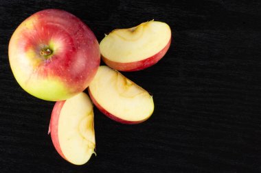Tüm üç dilim bir taze kırmızı elma grup james yas siyah ahşap üzerine çeşitli flatlay