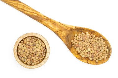 Tüm çiğ yeşil mercimek tohum zeytin tahta kaşık ve üzerinde beyaz izole ahşap kase flatlay sürü