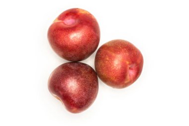 Grup üç bütün taze pluot interspecific Erik çeşitli flatlay beyaz izole