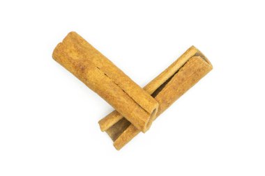 Beyaz arka plan üzerinde izole iki bütün kuru kahverengi tarçın çubuğu flatlay grubu