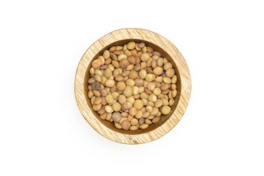 Tüm çiğ yeşil mercimek tohumları üzerinde beyaz izole bir ahşap kase flatlay sürü
