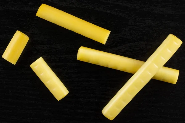 Smoked slovak string cheese stick on black wood