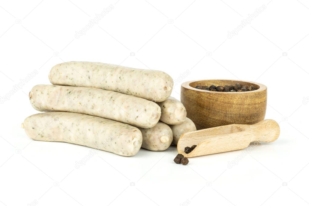 Group of six whole bavarian white sausage stack with black pepper in a wooden bowl isolated on white