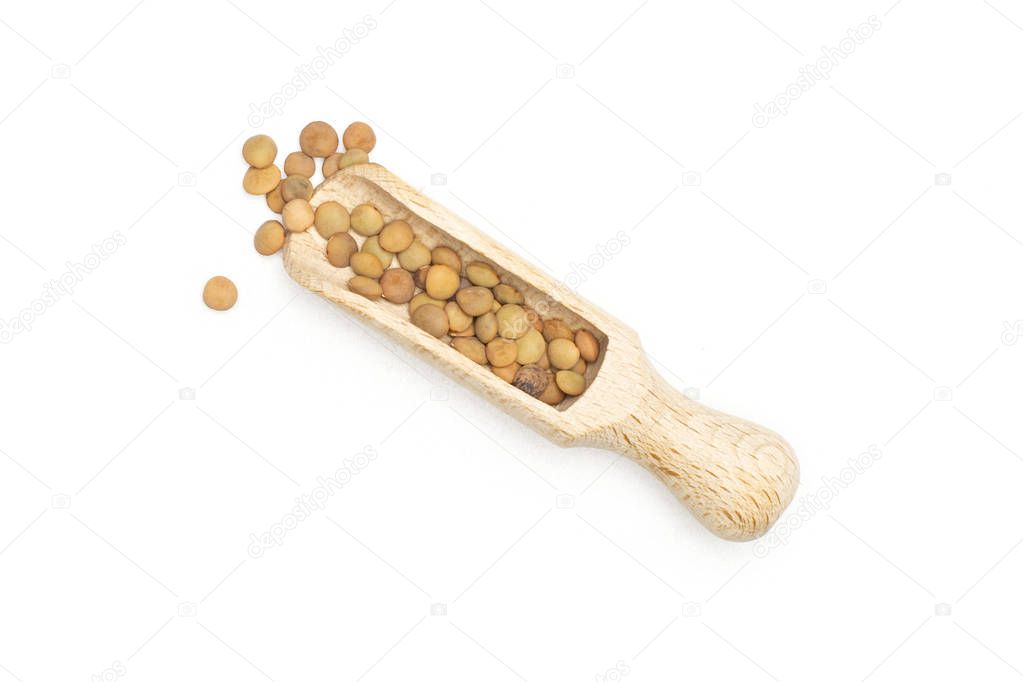 Lot of whole raw green lentil seeds in a wood scoop flatlay isolated on white
