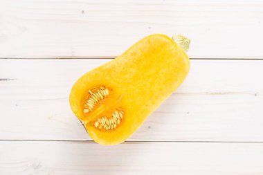 Yarı yumuşak armut biçimli turuncu Balkabagi waltham çeşitli flatlay beyaz tahta üzerinde