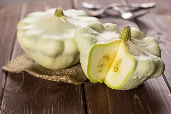 Grup iki bütün yaz beyaz pattypan Squash bir kahverengi ahşap üzerine keten kumaş üzerine dilimlenmiş