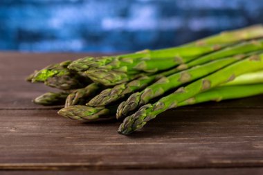 Bütün taze yeşil kuşkonmaz mızrak kahverengi ahşap üzerine çok