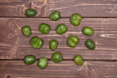 Bütün taze yeşil mini bebek Kivi Meyve flatlay kahverengi ahşap üzerine çok