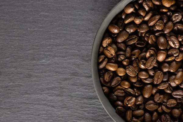 Grãos de café marrom escuro doce arábica em pedra cinza — Fotografia de Stock