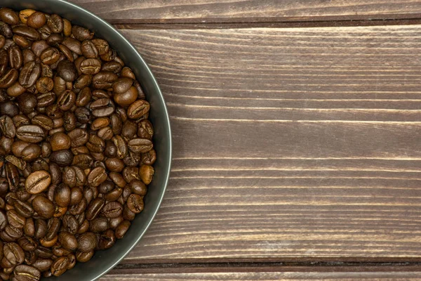 Dark brown coffee beans sweet arabica on brown wood