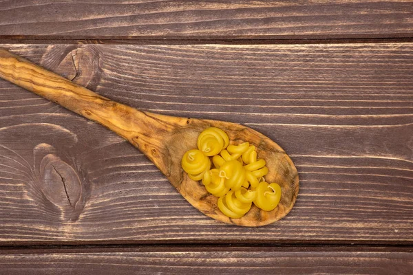 Funghetto de pasta cruda sobre madera marrón — Foto de Stock