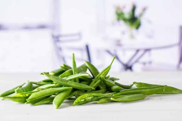 Guisante de azúcar verde con tulipanes rojos — Foto de Stock