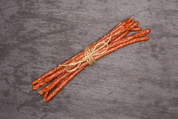 Spicy tyrolini salami stick on grey stone — Stock Photo, Image