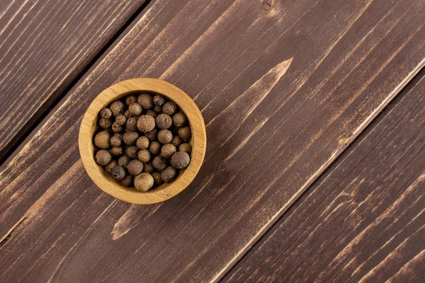 Bayas secas de pimienta de Jamaica sobre madera marrón —  Fotos de Stock