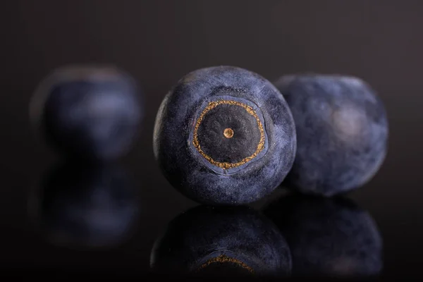 Fresh sweet blueberry isolated on black glass — Stock Photo, Image